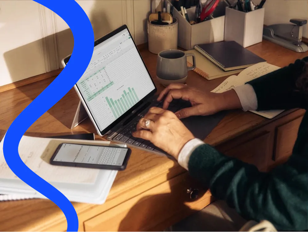 Someone at a laptop reviewing a spreadsheet of results with a bar chart